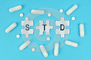 On a blue background, there are pills and puzzles with the inscription - STD