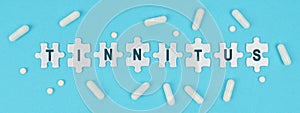 On a blue background, there are pills and puzzles with the inscription - TINNITUS