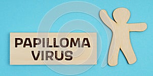On a blue background, a wooden figure of a man and a plate with the inscription - PAPILLOMA VIRUS