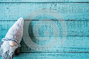 Blue background of a wooden table with a Santa toy on it, copy space