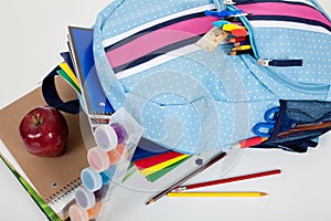 Blue backpack full of supplies on white