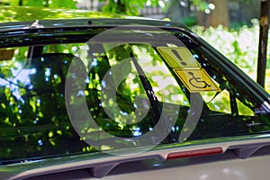 Blue Badge Holder sign. White and blue sticker with a wheel chair symbol on stuck to the inside of a car window