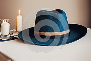 Blue bailey hat and candle, cream background with Generative AI