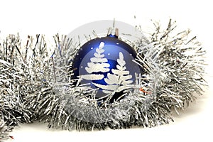Blue ball with christmas tree on silver tinsel