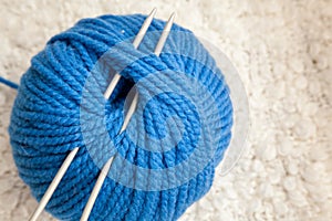 Blue ball of wool yarn for close-up knitting on a white background