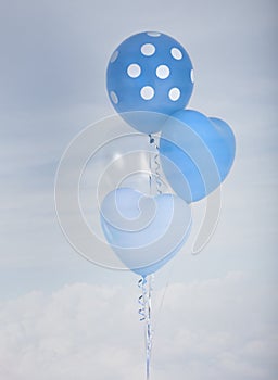 Blue balloons in heart shape and polka dot over blue sky background with retro filter effect