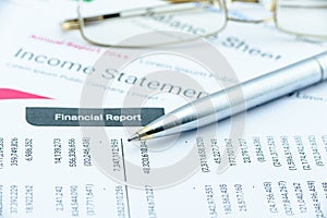 Blue ballpoint pen on a quarterly corporate financial report on a table. photo