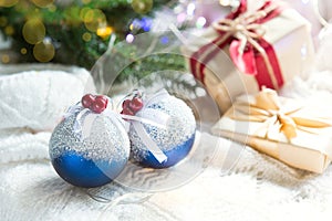 Blue balls with artificial snow, Christmas gift boxes and decorations on a white knitted blanket. New year, festive atmosphere, sp