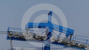 The blue bar of chair lift station on ski resort working and spinning isolate.