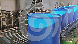 Blue barrels on an automated line in a factory. The process of colorization in the factory