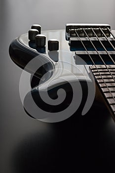 A blue bass guitar positioned against a dark wooden background