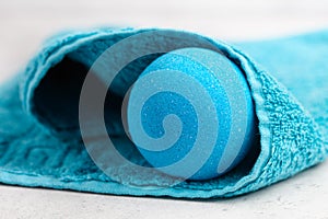 Blue bath bomb wrapped in towel