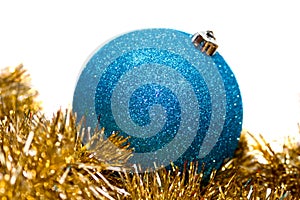 Blue bauble on gold tinsel