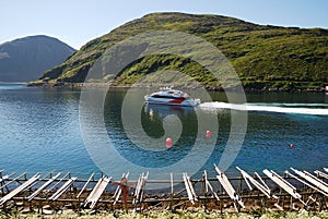 Blue bay with speedboat and wooden rackes.