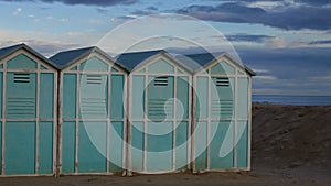 Blue beach sheds on the sand in a winter day Italy, Europe