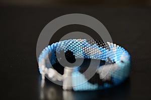 Blue beaded bracelet camouflage coloring on a dark background