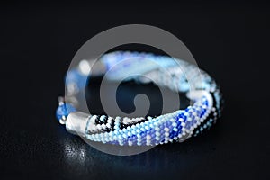 Blue beaded bracelet with greek ornament on a dark background