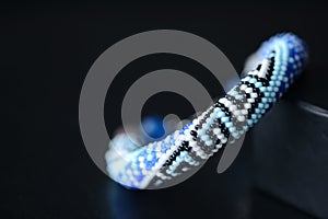 Blue beaded bracelet with greek ornament on a dark background