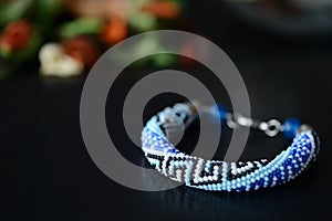 Blue beaded bracelet with greek ornament on a dark background