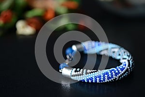 Blue beaded bracelet with greek ornament on a dark background