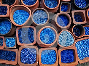 Blue beads in terra cotta pots.