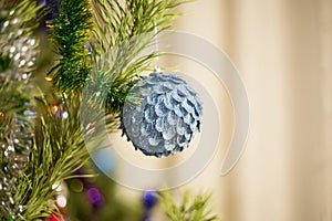 The blue beautiful ball weighs on the New Year green tree decorated with garlands and tinsel