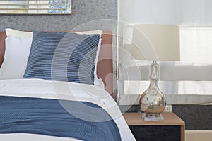 Blue bedding style and classic style white reading lamp in bedroom