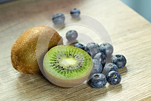 Blue berries or blueberries and kiwi fruit bunches on the desk wood background of bright colors are naturally nutritious and fresh