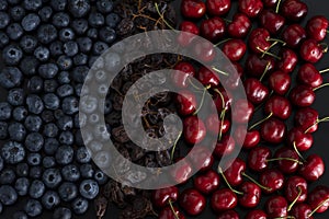 Blue berries, dried sultanas and cherries on black background