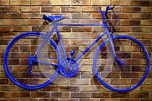 Blue bicycle on a brick wall.