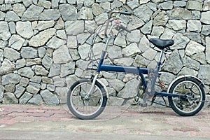 Blue bicycle with stone  background,vintage effect filter