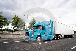 Blue big rig semi truck with dry van semi trailer transporting c