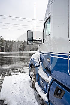 Blue big rig semi truck tractor high cab with truck driver rest compartment standing for truck driver rest on the industrial truck