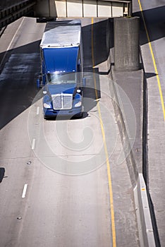 Blue big rig semi truck transporting commercial cargo in reefer