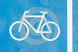 Blue bike symbol on blue road . Bikeway photo.