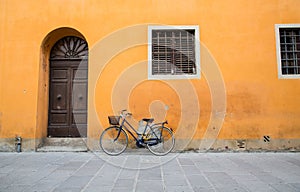 Blue Bike with Yellow Chain on Orange Wall
