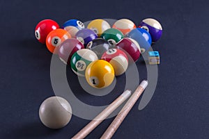Blue billiard table with balls and cue.
