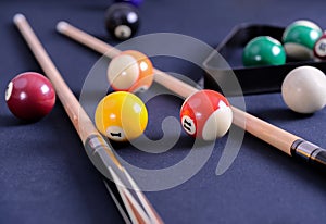 Blue billiard table with balls and cue.