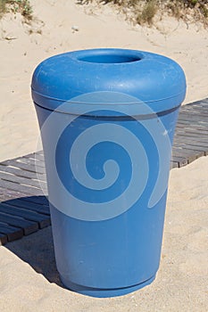 Blue bin on sand