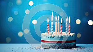 Blue birthday cake with lit candles. A small delicious cake on a blue background