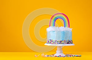 Blue Birthday Cake with Rainbow topper on Yellow