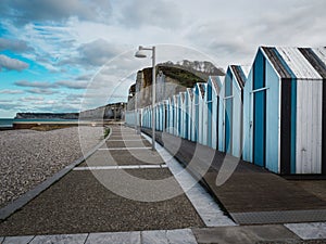 Blue and black beach huts on the pebble beach of Yport, Normandy