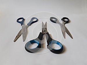 Blue and black handle of stainless steel scissors.