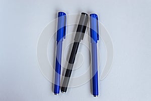 Blue and black penes for writing on a white background