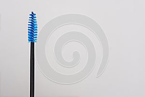 Blue and black yelash brush in hand girl master eyelash extension.