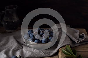 Blue blackthorn or sloe berries on the white bowl