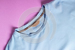 Blue blank t-shirt with blank clothing tag, label blank mockup template on a pink background