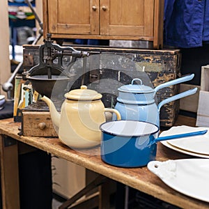 blue and blue ladles and teapots against the background of an old coffee grinder in an antique market