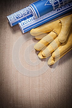 Blue blueprints leather protective gloves on wooden board constr