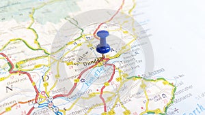 A blue board pin stuck in Dundee on a map of Scotland photo